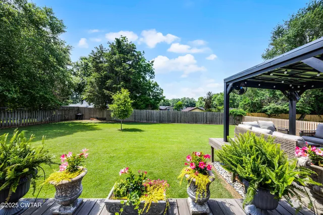 a view of a garden with plants and large trees