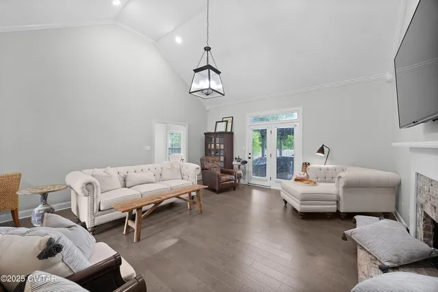 a living room with furniture chandelier and a window