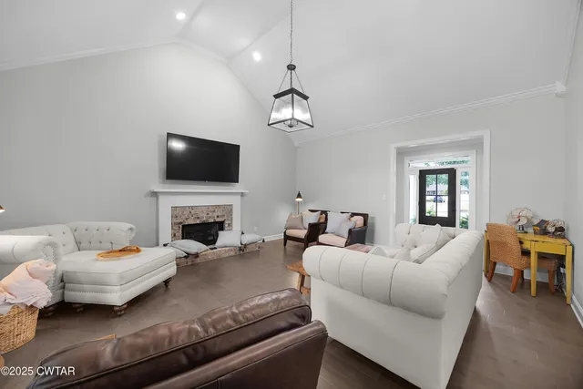 a living room with furniture a fireplace and a flat screen tv