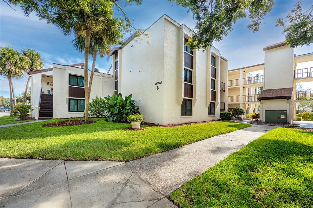 2207 Belleair Road, Unit B4 Clearwater, FL 33764 - Photo 34 of 37 a view of a house with a yard and palm trees