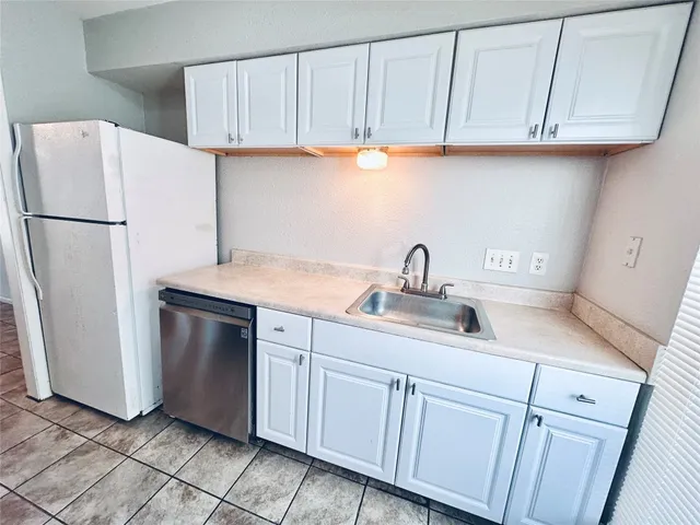 a kitchen with a stove a refrigerator and a sink