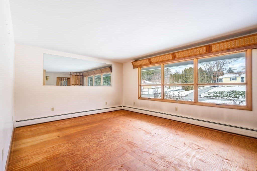 85 Charlton Road Dudley, MA 01571 - Photo 7 of 27 an empty room with wooden floor and windows