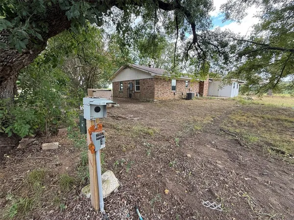 a front view of a house with a yard and tree