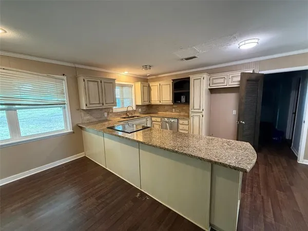 a kitchen with stainless steel appliances granite countertop a sink window and wooden floor