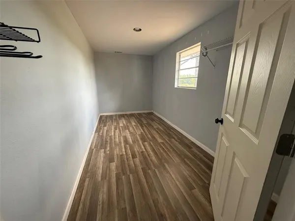 a view of a room with wooden floor and window
