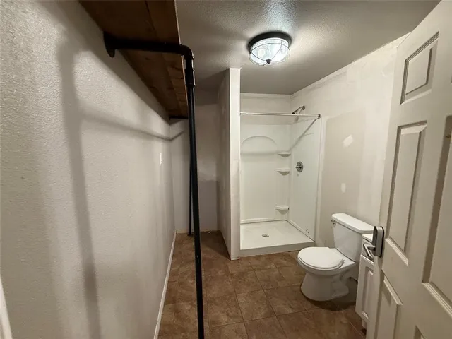 a bathroom with a toilet a sink and shower