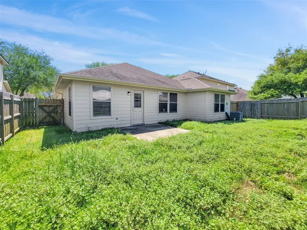 a view of a house with a yard and fence