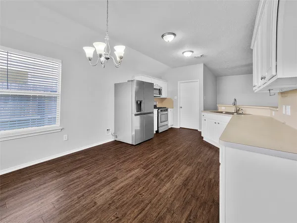 a view of a kitchen with a sink and dishwasher a refrigerator with wooden floor