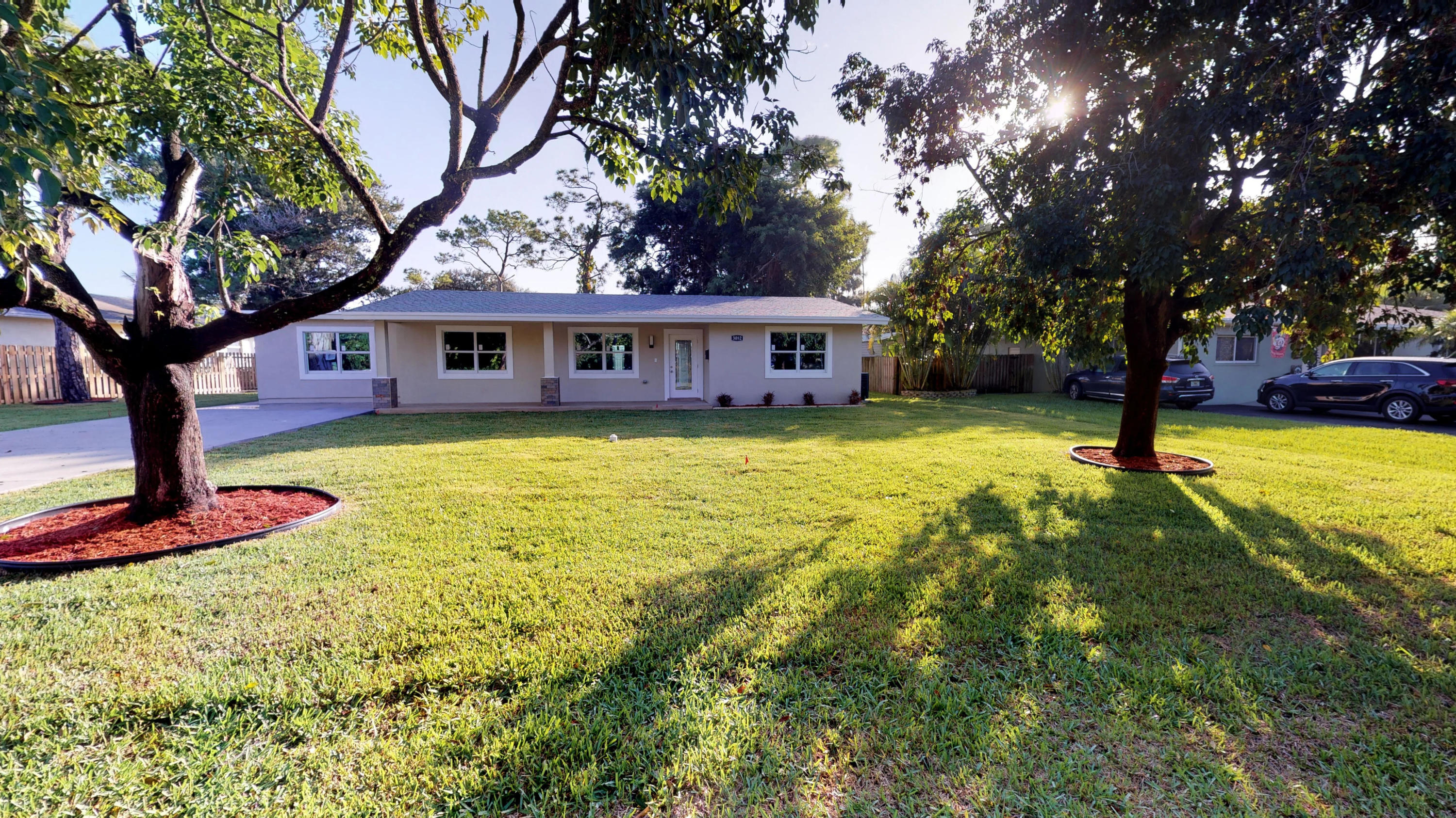 3082 Rostan Lane Palm Springs, FL 33461 - Photo 11 of 20 a view of a house with a yard patio and a tree