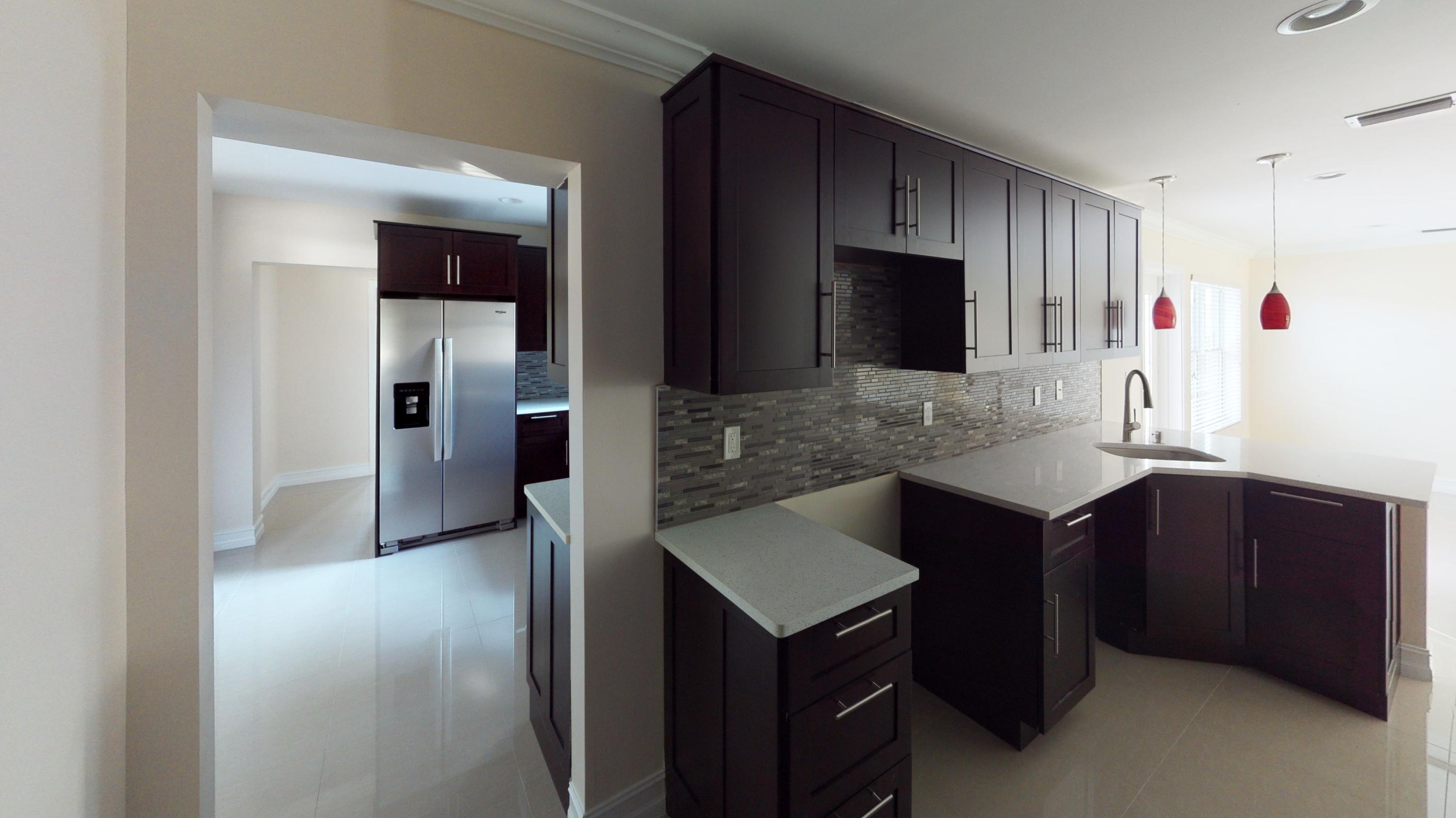 3082 Rostan Lane Palm Springs, FL 33461 - Photo 12 of 20 a kitchen with a sink and a refrigerator