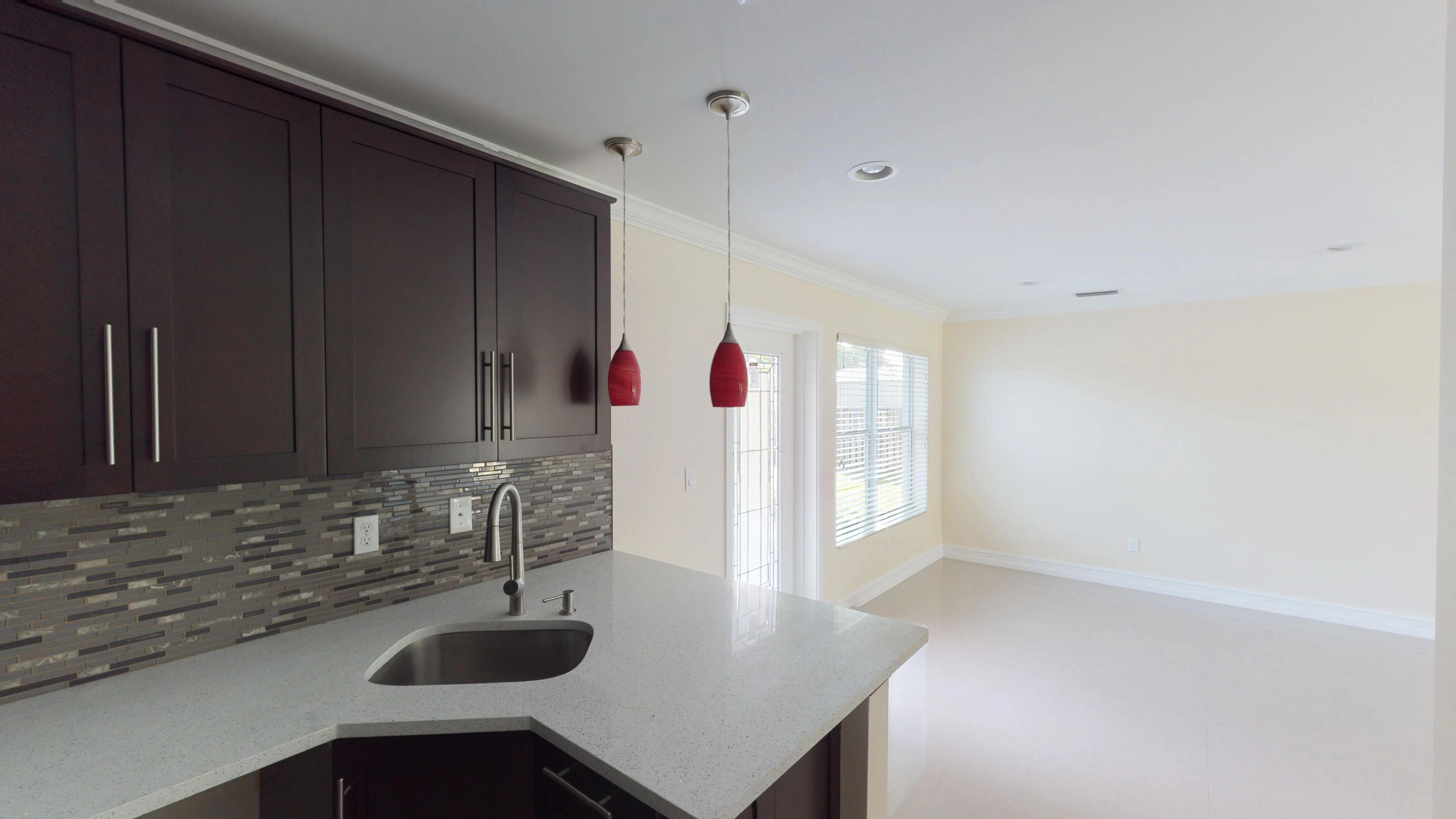 3082 Rostan Lane Palm Springs, FL 33461 - Photo 2 of 20 a kitchen with a sink and a mirror