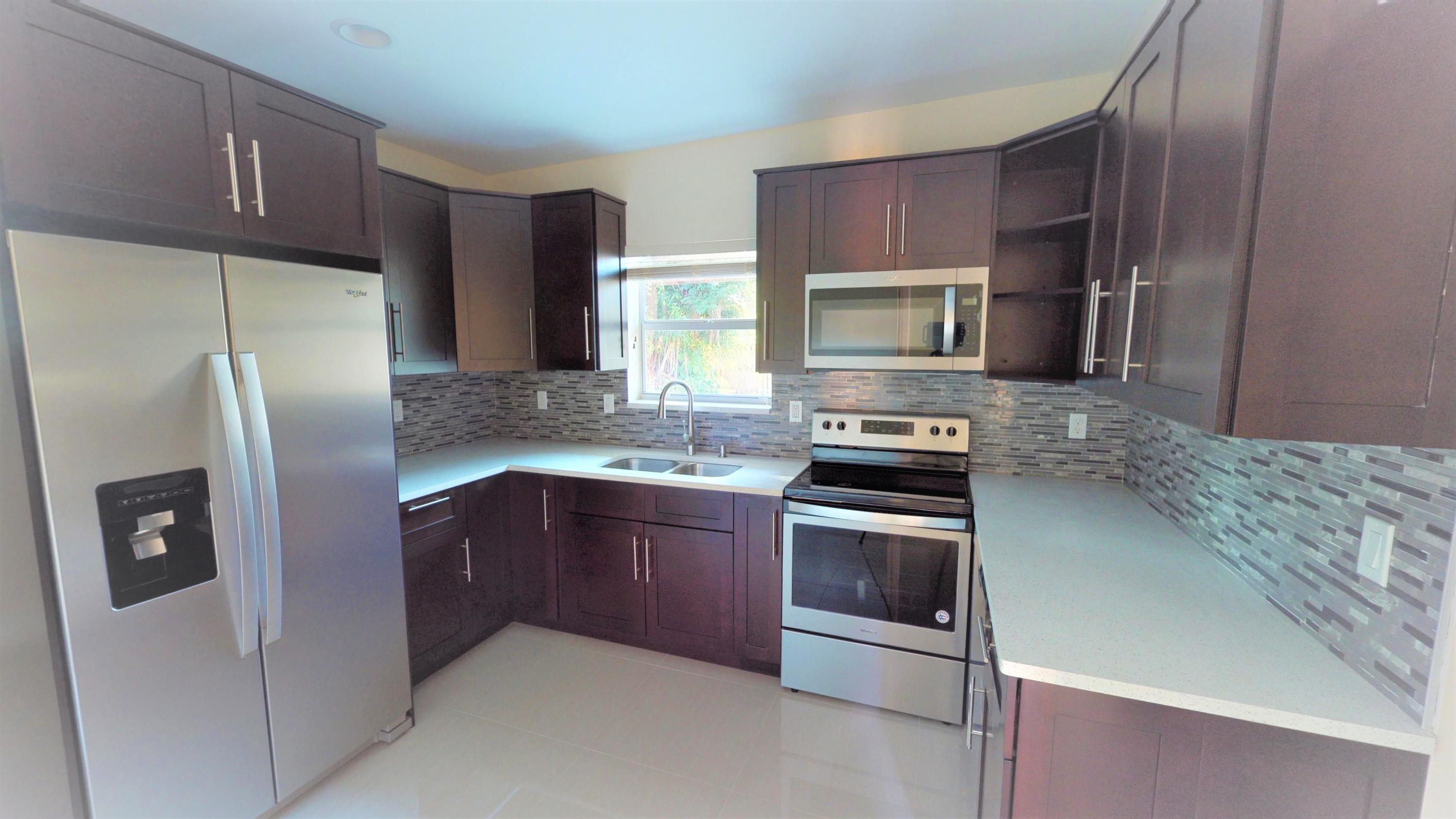 3082 Rostan Lane Palm Springs, FL 33461 - Photo 6 of 20 a kitchen with granite countertop stainless steel appliances and wooden cabinets