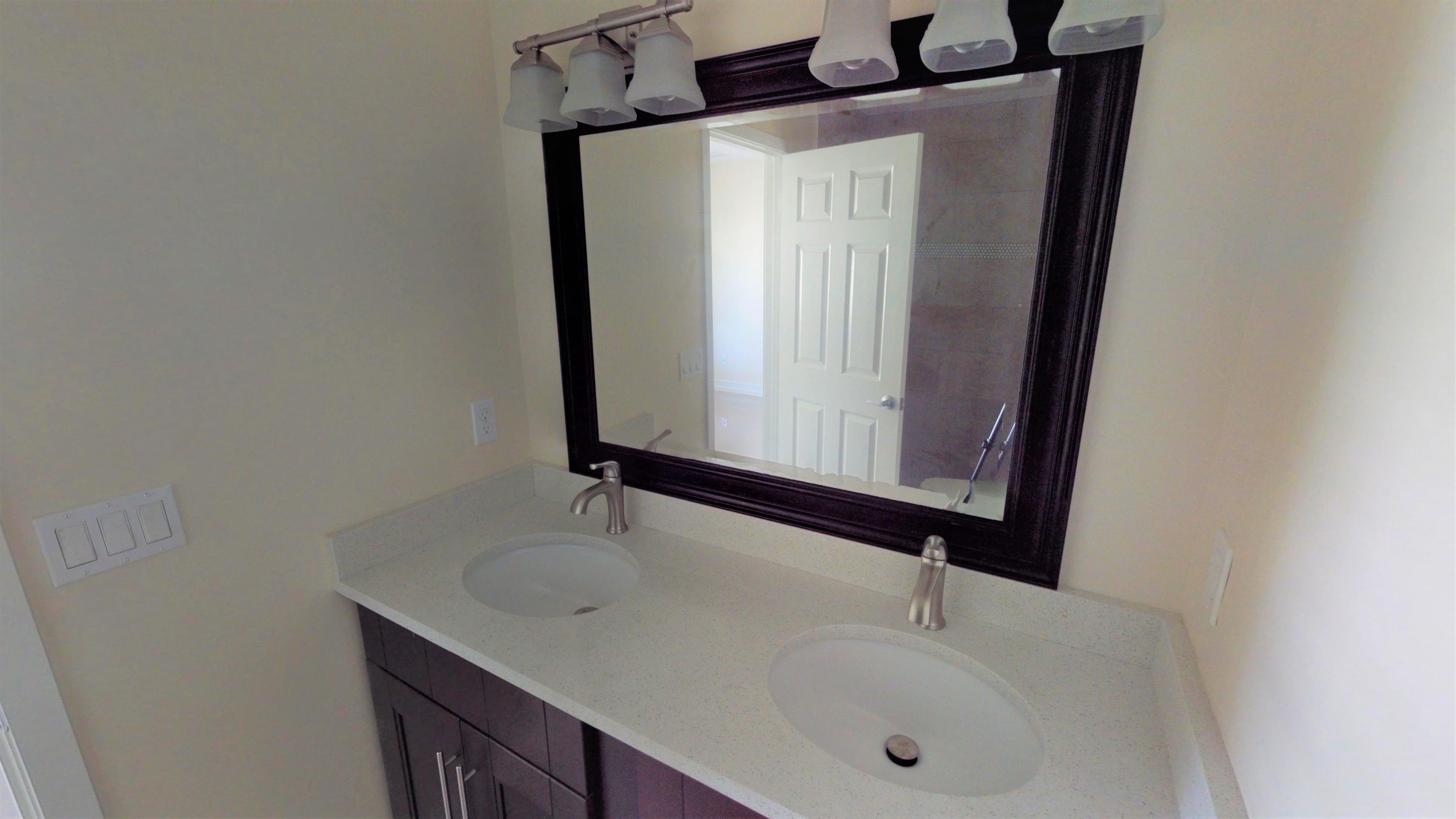 3082 Rostan Lane Palm Springs, FL 33461 - Photo 8 of 20 a bathroom with a sink and a mirror