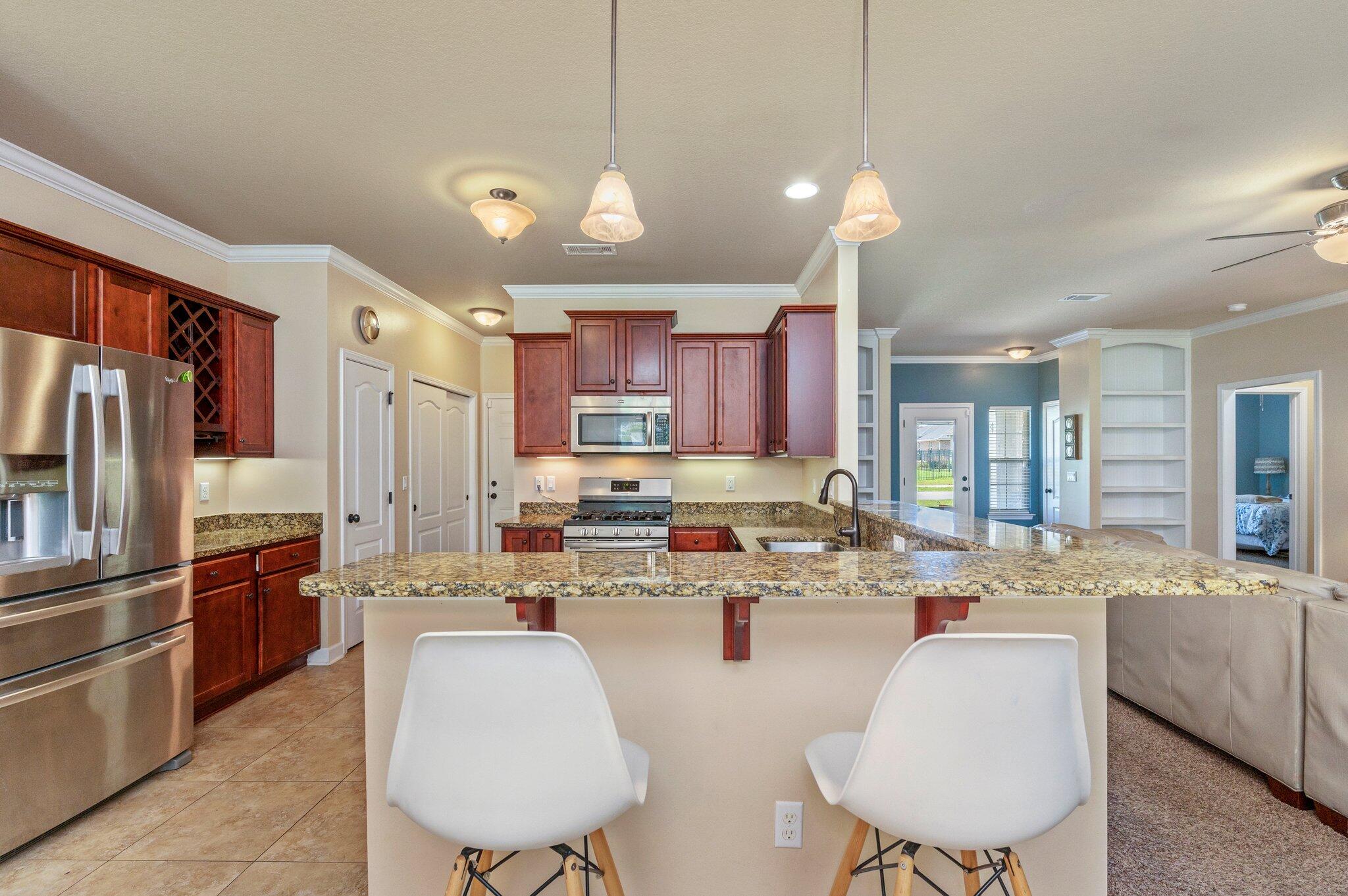 4615 Chanan Drive Crestview, FL 32539 - Photo 16 of 47 a kitchen with stainless steel appliances kitchen island granite countertop a sink refrigerator and cabinets