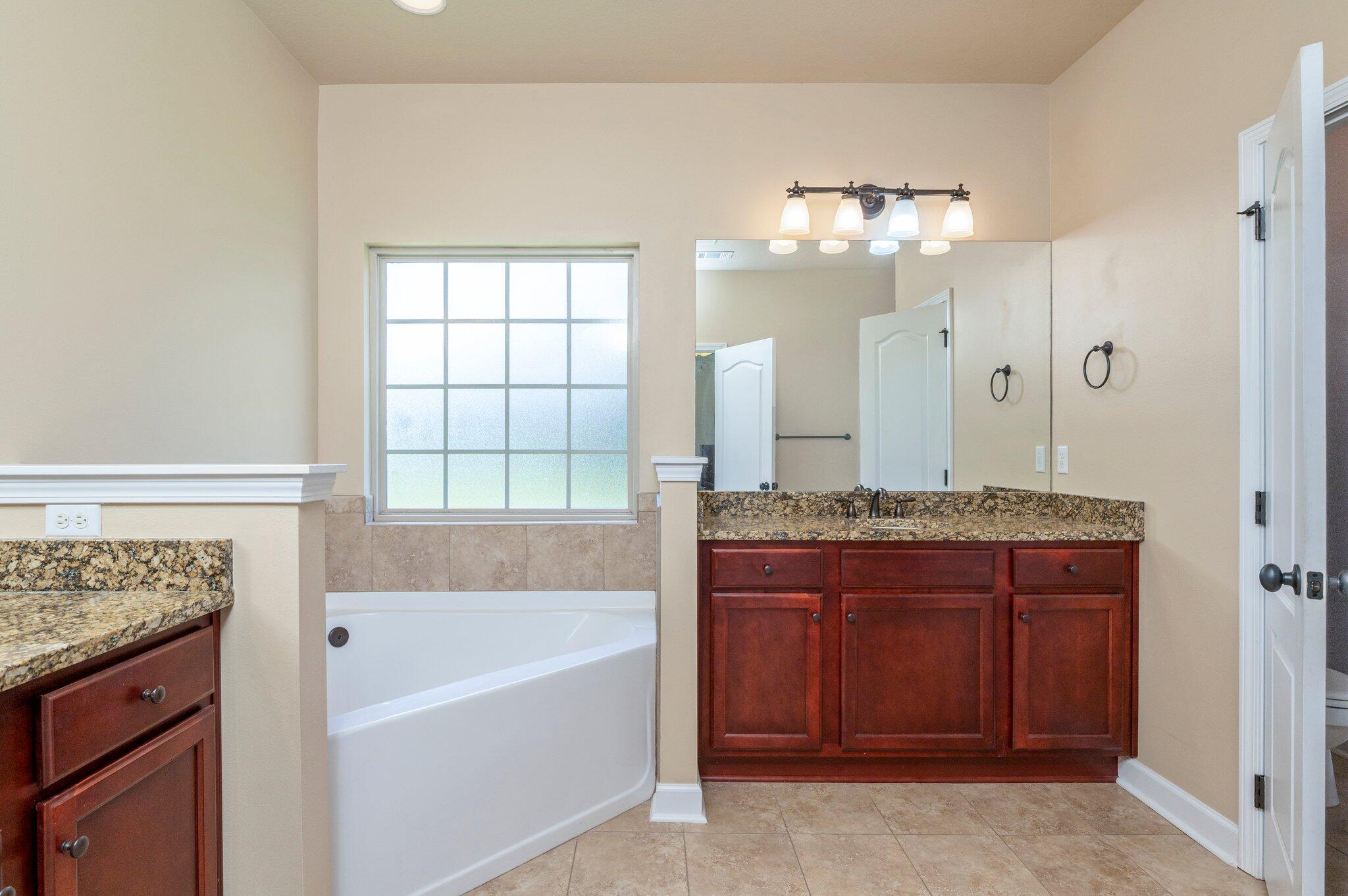4615 Chanan Drive Crestview, FL 32539 - Photo 27 of 47 a bathroom with a tub a sink and a mirror