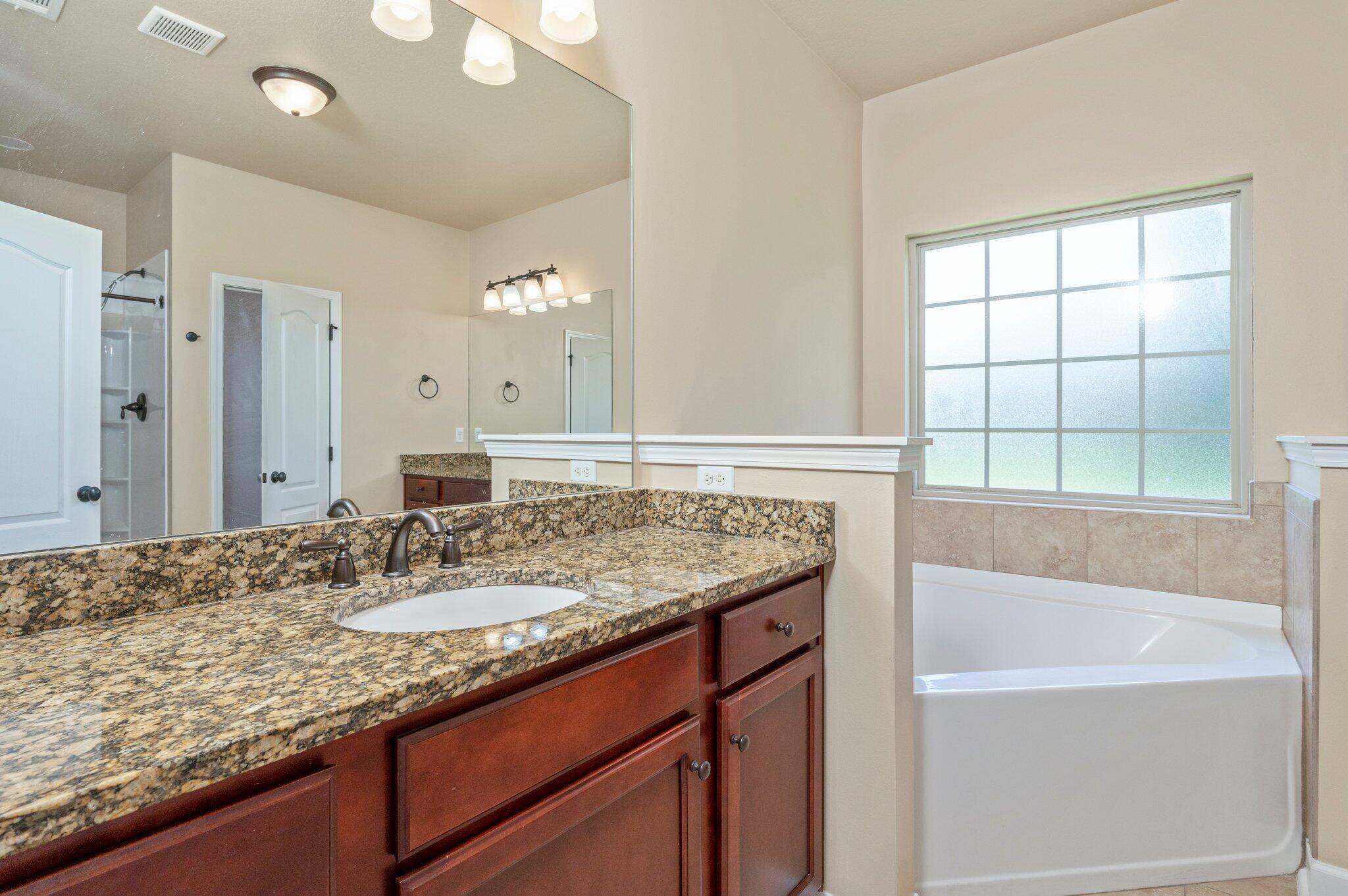 4615 Chanan Drive Crestview, FL 32539 - Photo 28 of 47 a bathroom with a granite countertop sink and a bathtub