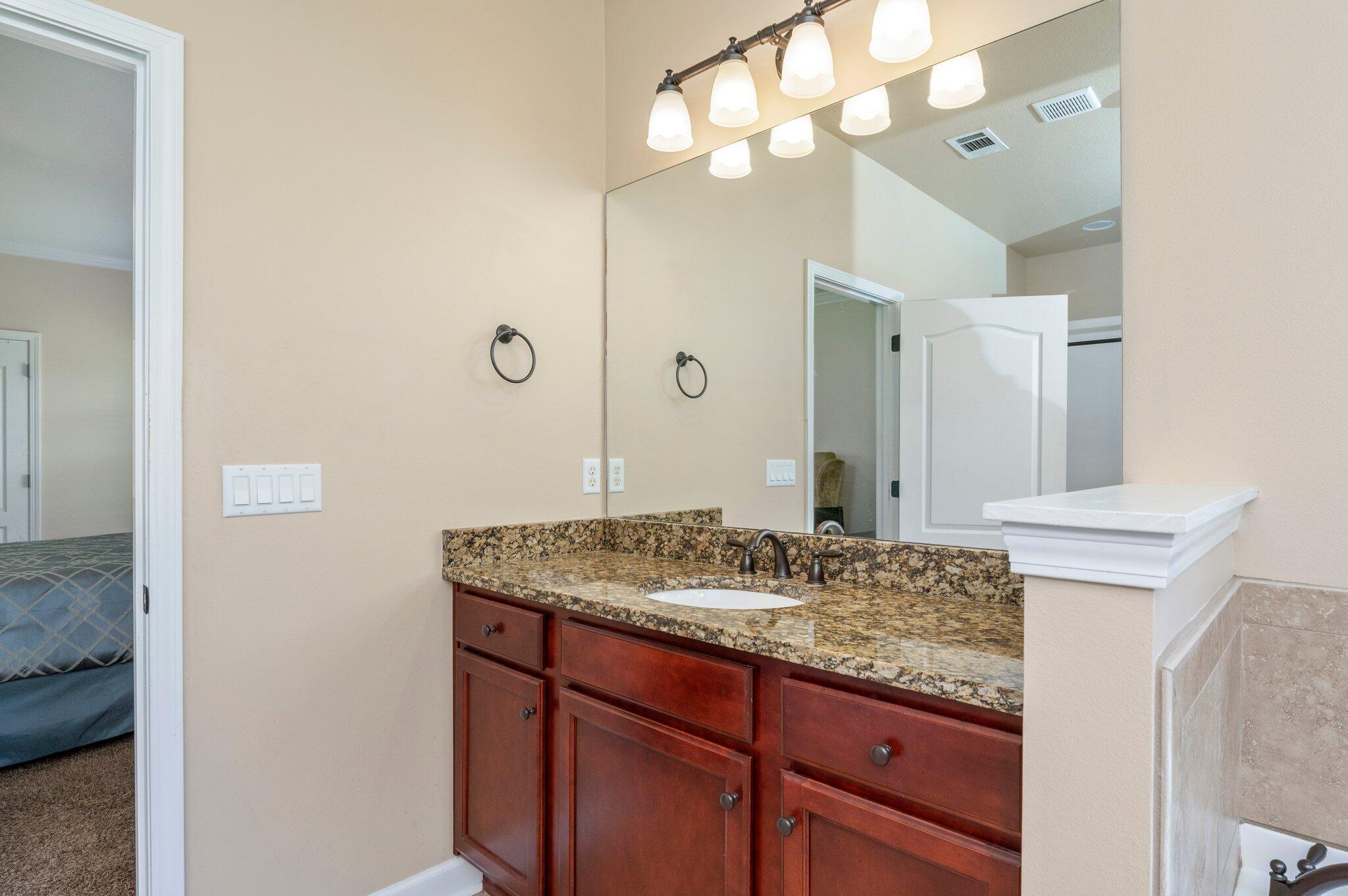 4615 Chanan Drive Crestview, FL 32539 - Photo 32 of 47 a bathroom with a granite countertop double vanity sink and a mirror