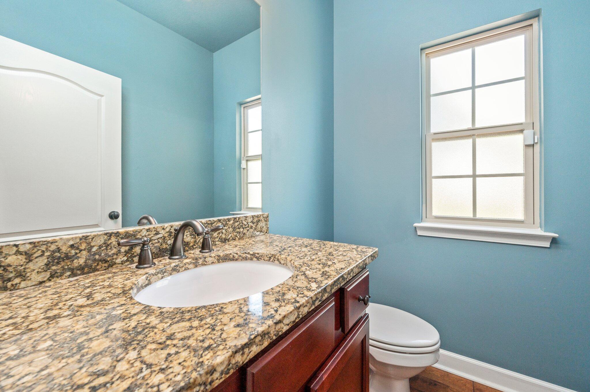 4615 Chanan Drive Crestview, FL 32539 - Photo 9 of 47 a bathroom with a granite countertop sink a toilet and a window