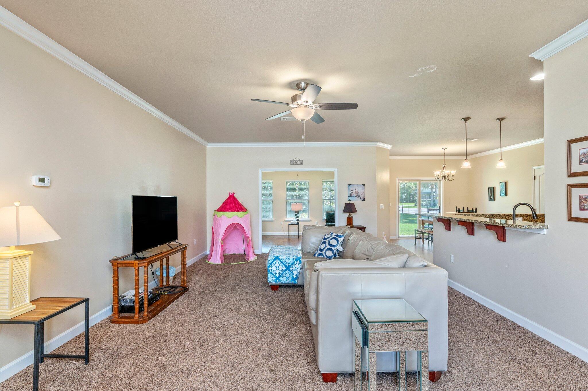 4615 Chanan Drive Crestview, FL 32539 - Photo 10 of 47 a living room with furniture a flat screen tv and kitchen view