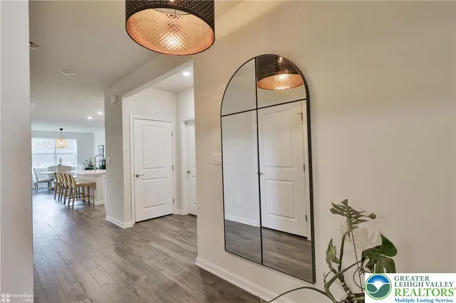 a kitchen with stainless steel appliances granite countertop a stove a sink a refrigerator and white cabinets with wooden floor