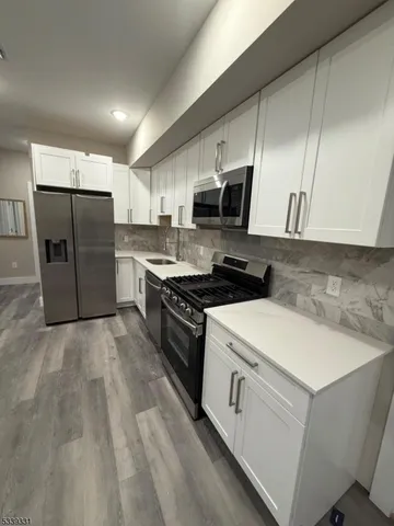 a kitchen with stainless steel appliances a refrigerator stove and microwave