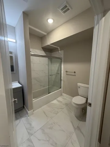 a bathroom with a toilet and a shower