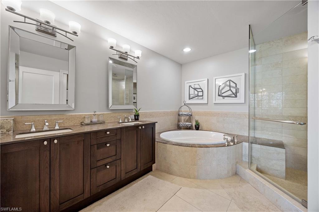 9123 Strada Place, Unit 7404 Naples, FL 34108 - Photo 13 of 36 a bathroom with a bathtub sink mirror and toilet
