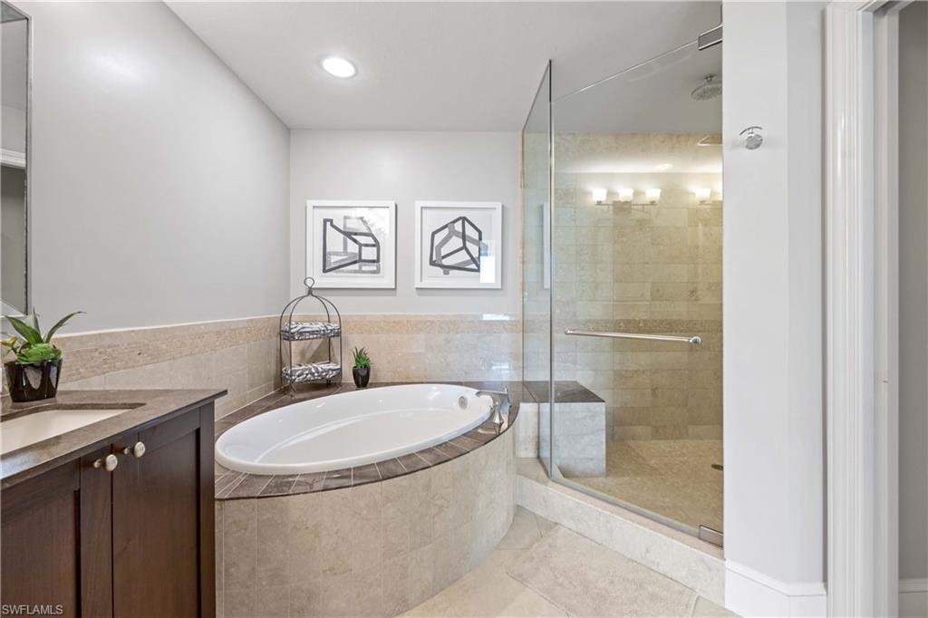 9123 Strada Place, Unit 7404 Naples, FL 34108 - Photo 14 of 36 a bathroom with a granite countertop sink a toilet a mirror and shower