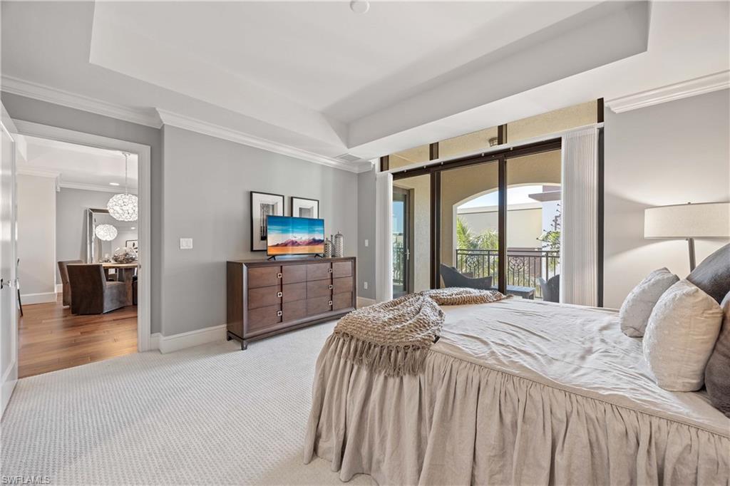 9123 Strada Place, Unit 7404 Naples, FL 34108 - Photo 16 of 36 a bedroom with a bed and a large mirror