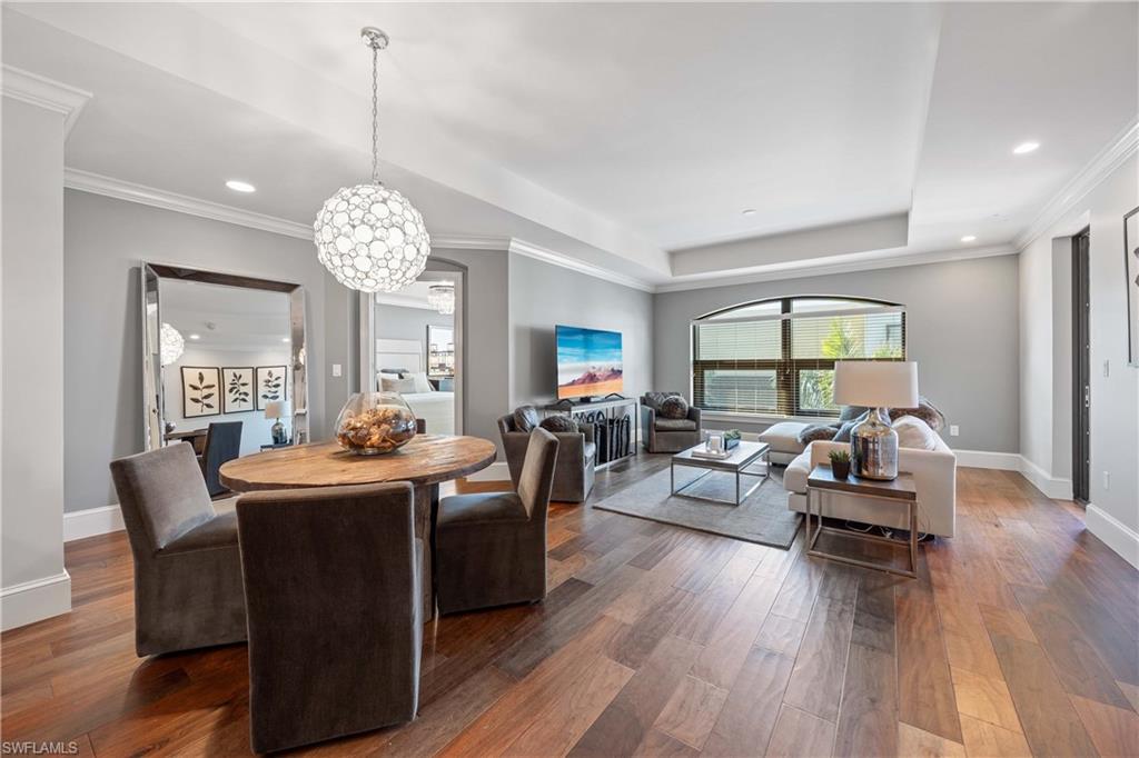 9123 Strada Place, Unit 7404 Naples, FL 34108 - Photo 3 of 36 a living room with fireplace furniture and a wooden floor