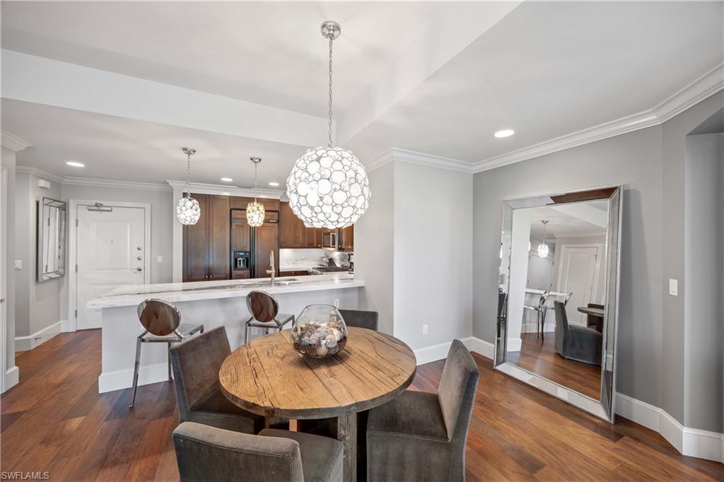 9123 Strada Place, Unit 7404 Naples, FL 34108 - Photo 10 of 36 a view of a dining room and livingroom with furniture wooden floor a chandelier