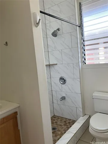a bathroom with a granite countertop shower and a toilet