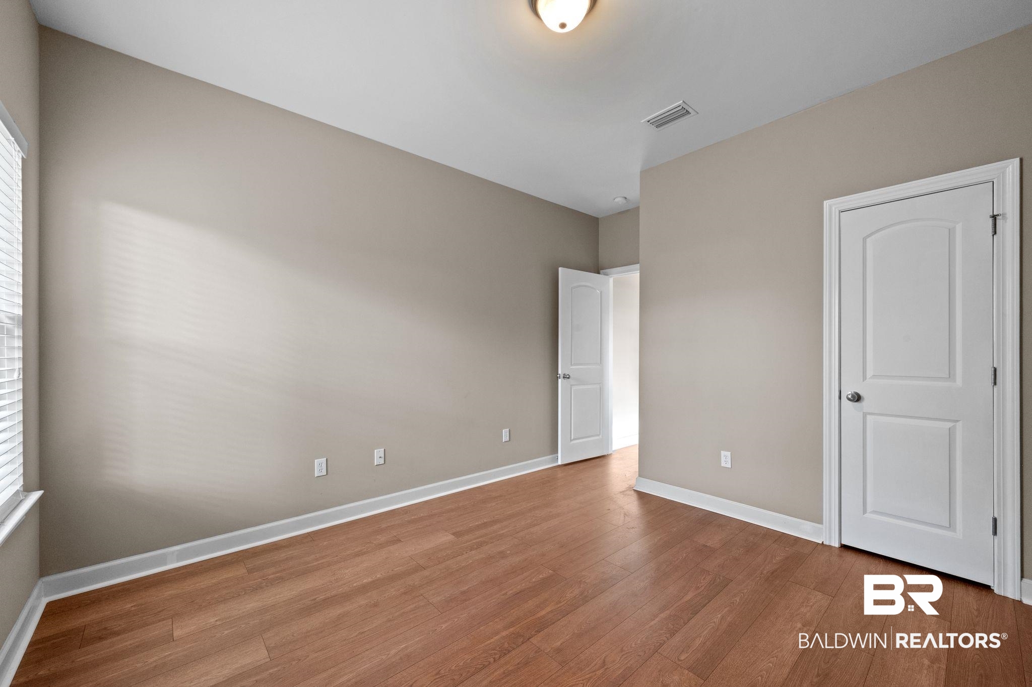 9381 Sable Court Daphne, AL 36526 - Photo 34 of 42 Unfurnished bedroom with visible vents, baseboards, and wood finished floors