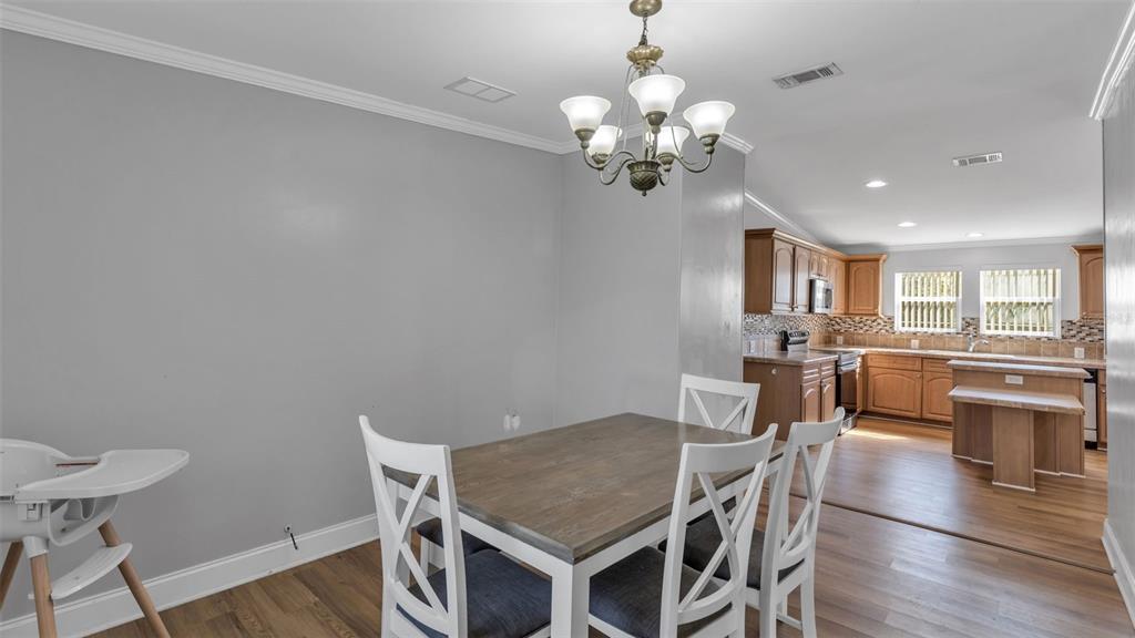 7549 Sinkhole Road Bartow, FL 33830 - Photo 20 of 40 a view of a dining room with furniture a chandelier and wooden floor
