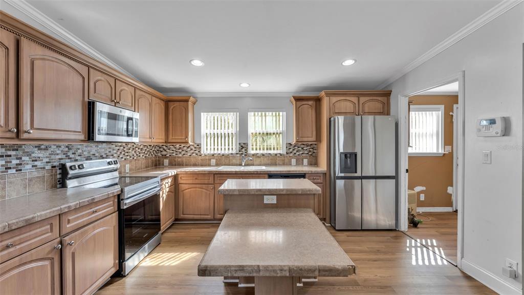 7549 Sinkhole Road Bartow, FL 33830 - Photo 25 of 40 a kitchen with a refrigerator sink and white cabinets