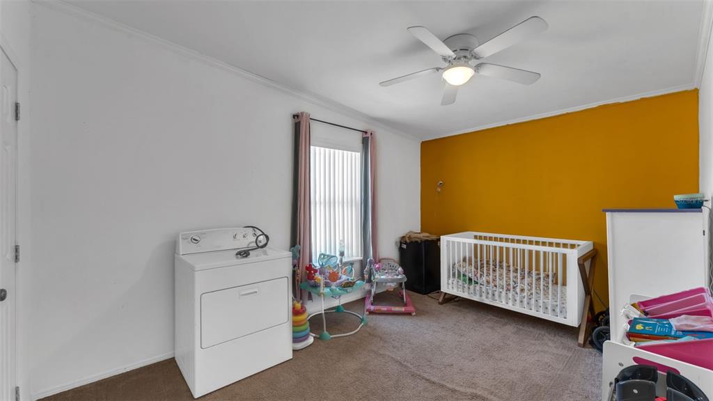 7549 Sinkhole Road Bartow, FL 33830 - Photo 28 of 40 a room with a baby crib furniture and a chandelier