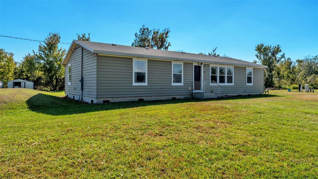 7549 Sinkhole Road Bartow, FL 33830 - Photo 7 of 40 a front view of house with yard and trees in the background