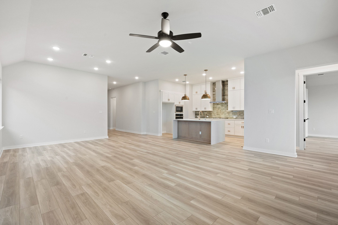 16201 Smithers Road Manor, TX 78653 - Photo 10 of 40 a view of an empty room with kitchen appliances and a ceiling fan