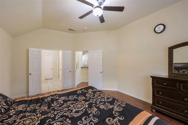 a bedroom with a bed and a flat tv screen on a dresser