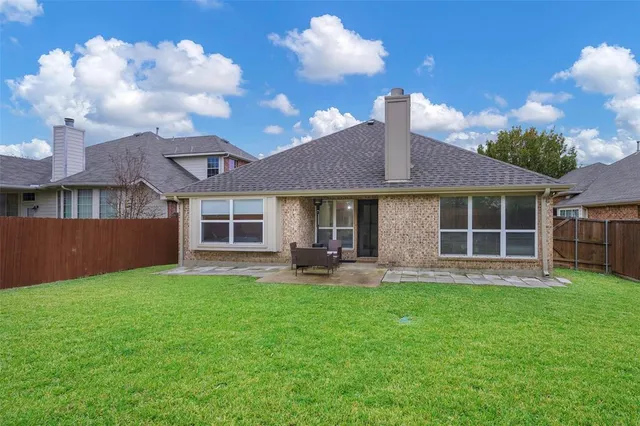 a front view of a house with a garden and trees