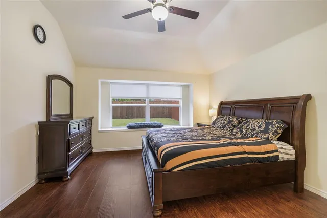a bedroom with a bed and a dresser next to a window