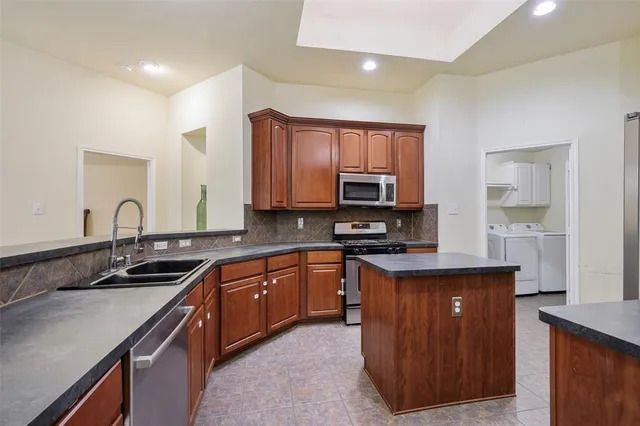 a kitchen with stainless steel appliances granite countertop a sink stove and cabinets