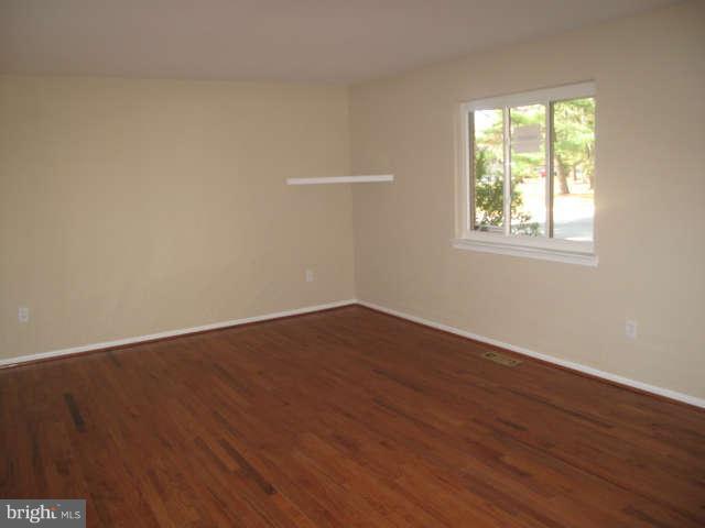 11034 Saffold Way Reston, VA 20190 - Photo 2 of 18 a view of an empty room with wooden floor and a window
