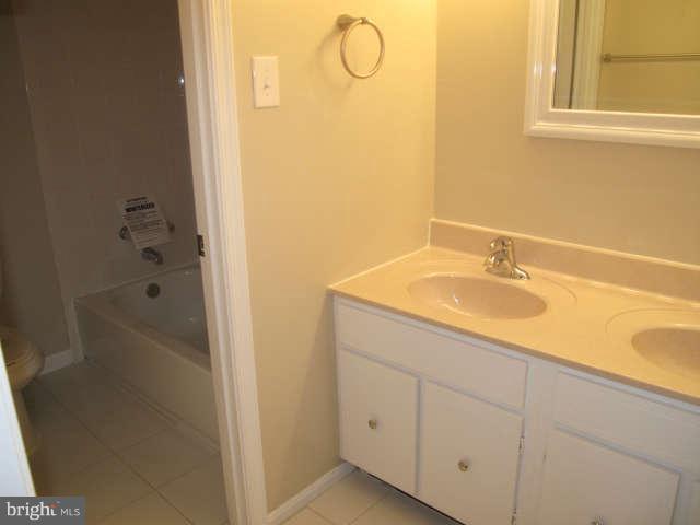 11034 Saffold Way Reston, VA 20190 - Photo 11 of 18 a bathroom with a granite countertop sink and a mirror