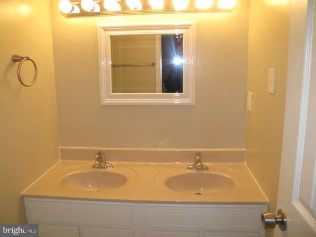11034 Saffold Way Reston, VA 20190 - Photo 12 of 18 a bathroom with a sink and a mirror