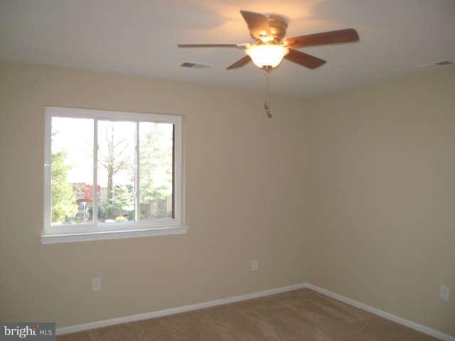11034 Saffold Way Reston, VA 20190 - Photo 13 of 18 an empty room with a window and a fan