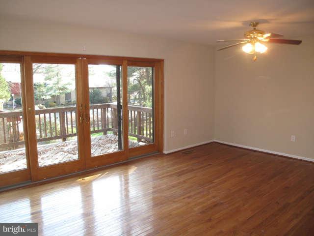 11034 Saffold Way Reston, VA 20190 - Photo 3 of 18 a view of an empty room with wooden floor and a window