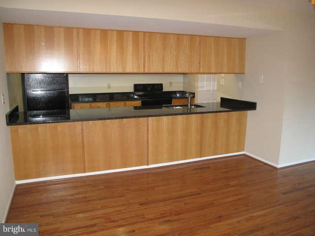 11034 Saffold Way Reston, VA 20190 - Photo 6 of 18 a view of kitchen with stainless steel appliances wooden floor and chair