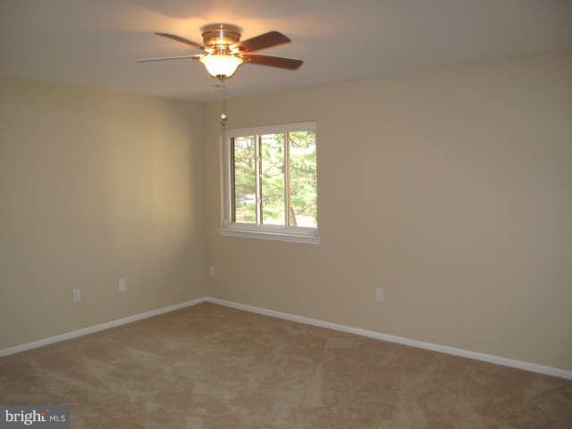 11034 Saffold Way Reston, VA 20190 - Photo 8 of 18 an empty room with a window and a fan
