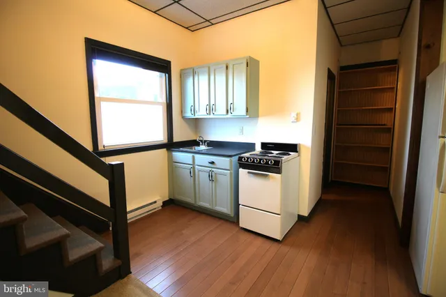a kitchen with sink cabinets and wooden floor
